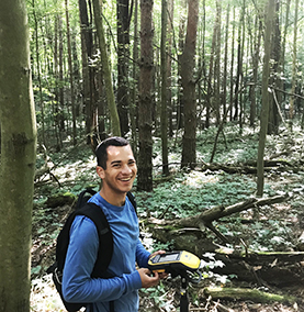 Kelson Perez '21 surveying plants in the Arboretum