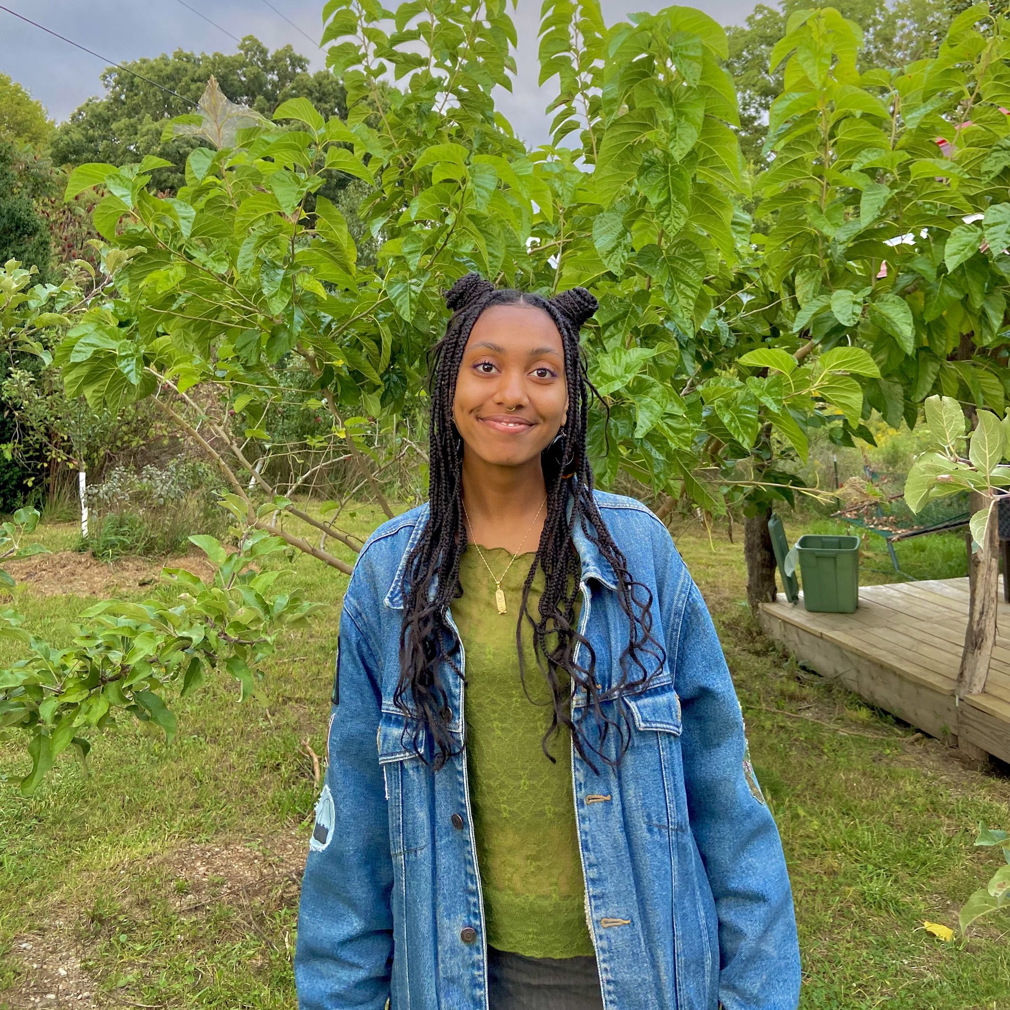 Jade Milton standing in front of an apple tree