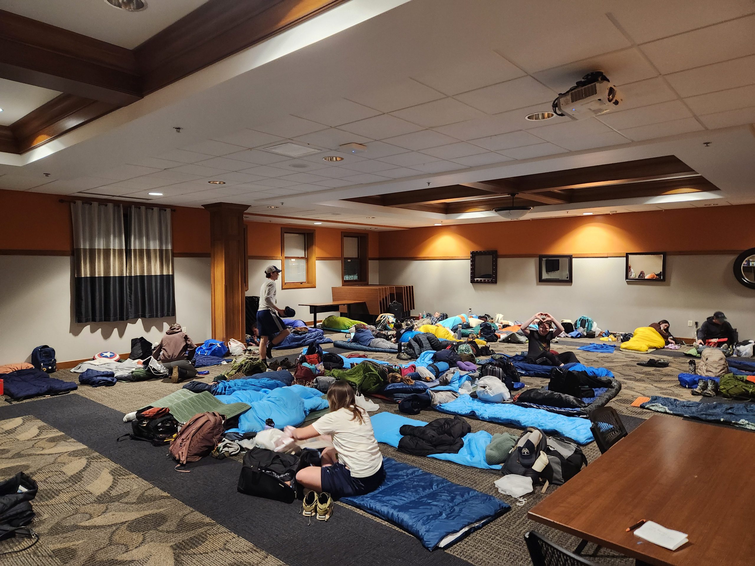Sleeping bags and backpacks sprawled across Banquet Hall