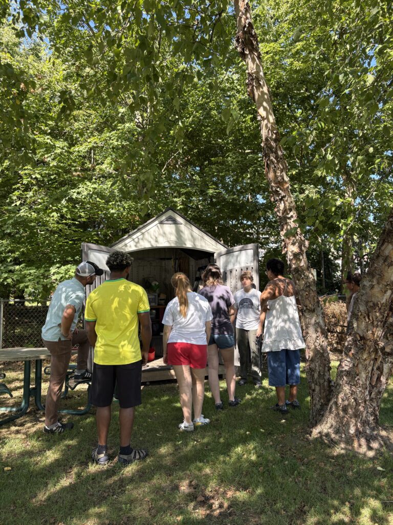 Group of students in front of an open shed