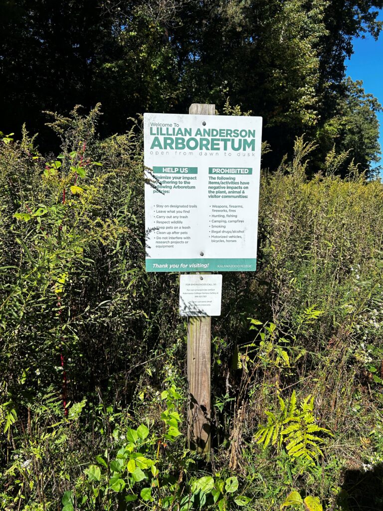 Green and white sign in front of plants that says "Welcome to Lillian Anderson Arboretum"
