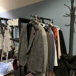 Clothing on a rack in a room with blue walls